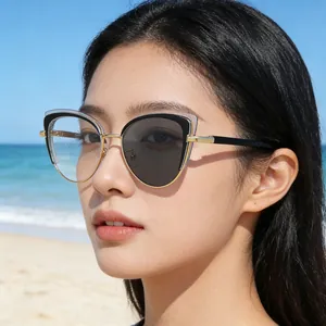 Gafas de sol fotocromáticas de ojo de gato con montura de metal negro y dorado en la playa