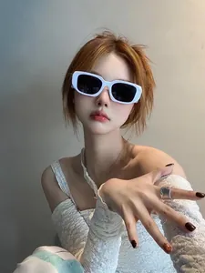 Lunettes de soleil rectangulaires blanches à monture large avec verres UV sur modèle féminin