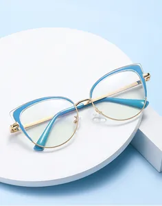 Primer plano de montura cat-eye en azul y dorado sobre un soporte blanco