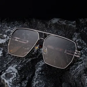Retro-Quadrat-Metallsonnenbrille mit Doppelsteg auf edlem schwarzem Felsenhintergrund