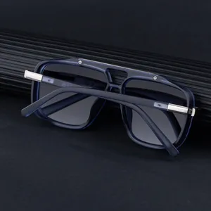 Détail de la monture de lunettes bleu marine avec rivets métalliques sur fond noir élégant