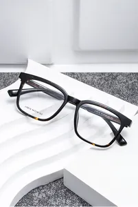 Détail d'une monture optique carrée noire et écaille sur un support géométrique blanc