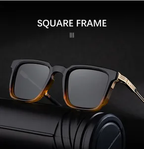 Détail de lunettes de soleil carrées dégradées avec branches dorées gravées et verres gris