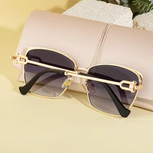 Gros plan de lunettes de soleil œil-de-chat avec monture dorée et verres dégradés sur étui