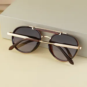 Détail de lunettes pilote vintage avec monture en métal doré et verres dégradés foncés