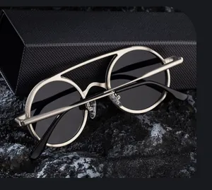 Détail de lunettes de soleil en métal argenté avec double pont et barre supérieure texturée