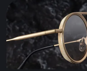 Détail de la monture en métal doré avec bords moletés vintage et verres gris foncés