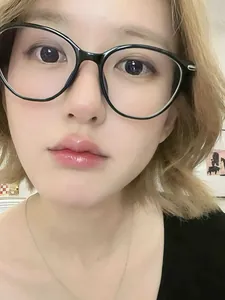 Close-up of retro black cat-eye glasses frame with silver metal accents on a model