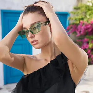 Fashionable square green transparent sunglasses with V-logo temple on a female model