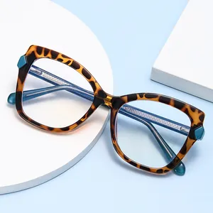Stylish tortoiseshell cat-eye glasses frame with blue-green accents on light blue background