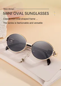 Detail of mini oval sunglasses with gold metal frame and dark gray lenses next to leather pouch