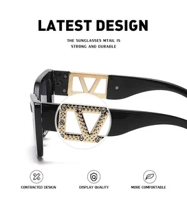 Close-up of black sunglasses with gold hollow metal temples and sparkling V decoration