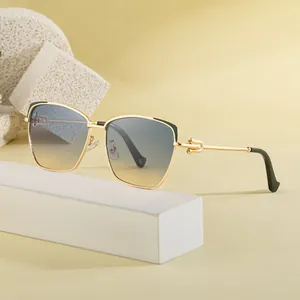 Lunettes de soleil œil-de-chat en métal doré avec verres dégradés sur marbre