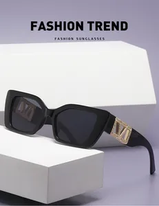Detailed view of black square cat-eye sunglasses with rhinestone-studded golden V metal logo