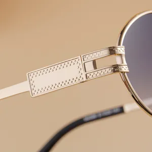 Detailed close-up of golden metal sunglass temples with rectangle hollow and dot texture