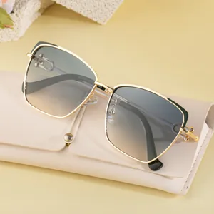 Lunettes de soleil œil-de-chat en métal avec verres dégradés sur une pochette en cuir