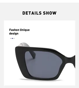 Close-up detail of black cat-eye sunglasses with polished frame and dark gray lenses