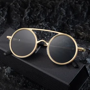 Lunettes de soleil ovales rétro avec monture dorée et double pont sur roche noire