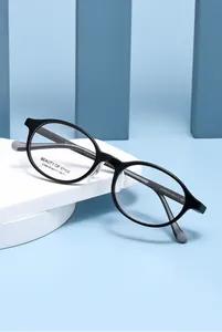 Detail van zwart ovaal optisch montuur met model AT68638 op blauwe achtergrond