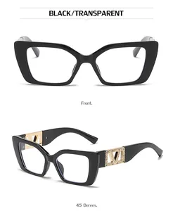 Detail of black cat-eye sunglasses with golden V-shaped rhinestone logo on temple