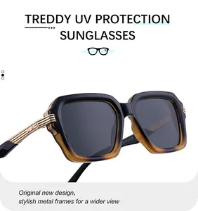 Détail de lunettes de soleil carrées avec monture bicolore et branches dorées