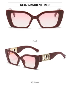 Detail of red square sunglasses featuring gradient lenses and golden V-shaped metal trim