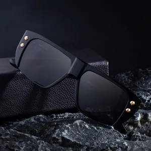 Modern square frame sunglasses with black frame and gold rivets on a dark premium box
