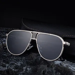 Classic silver pilot sunglasses with black lenses and leather case on rock background