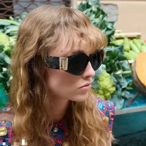 Detail of fashion sunglasses with thick black frames and bold gold metal temple accents