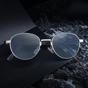 Slanke zilveren ovale metalen zonnebril met dun frame op een luxe getextureerde achtergrond