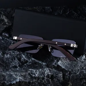 Detalle de gafas de sol sin montura con patillas de madera sobre estuche de cuero negro