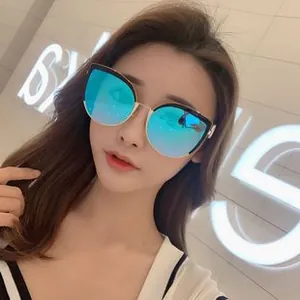 Nahaufnahme der blau verspiegelten Gläser bei Oversize-Cateye-Sonnenbrille mit Goldbügeln