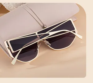 Detail of geometric gold sunglasses with dark lenses and beige leather case