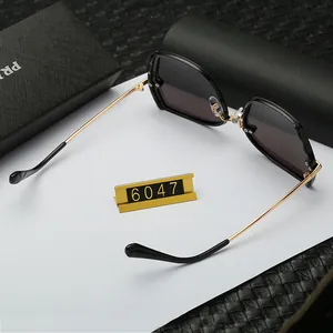 Detail of rimless polarized sunglasses with black frames and gold metal temples on a desk