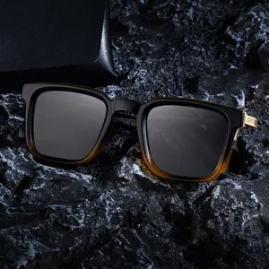 Lunettes de soleil polarisées carrées avec monture dégradée sur roche noire