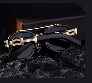 Detail of luxury oval sunglasses with golden metal hinges and black leather case