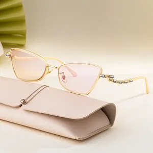 Cat eye sunglasses with gold frames and rhinestones on beige leather case