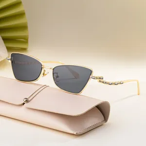 Cat eye sunglasses with gold frame and diamond accents with leather storage case