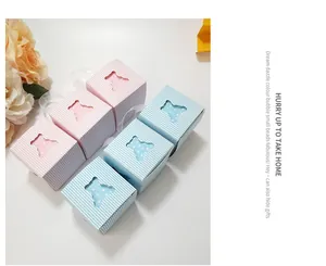 Detailed view of small hollow bear candy boxes in pink and blue with ribbon handles