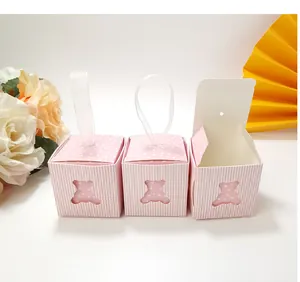 Pink striped candy box with bear cutout, satin ribbon, and floral gift arrangement