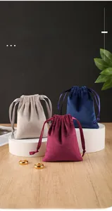Detail of luxury velvet drawstring jewelry bags in grey, wine red, and navy blue