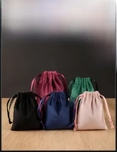 Detailed view of five multi-colored velvet drawstring pouches for jewelry storage on a table