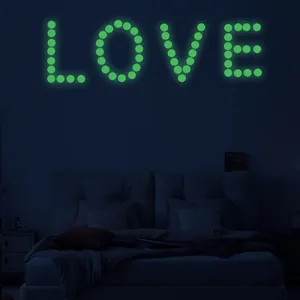 Luminous wall stickers forming the word LOVE in bright glow-in-the-dark green dots