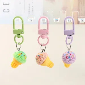 Three macaron-colored resin ice cream cone keychains with matching pastel hooks