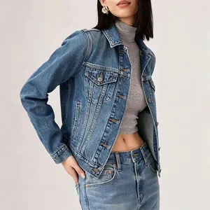 Detail of dark blue denim jacket featuring double chest pockets and metallic buttons