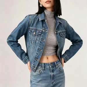 Detail of blue wash denim jacket with metal buttons over a grey cropped turtleneck