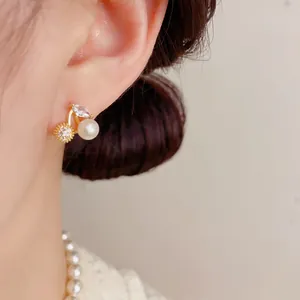 Close-up of cherry-shaped stud earring with white pearl and pave-set zircon detail