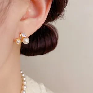 Exquisite pearl and zircon cherry stud earrings in gold plating worn by a model