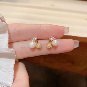 Macro detail of cherry earrings with white pearls and sparkling leaf-shaped zircons