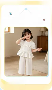 Detail of girls' white summer set featuring ruffled short sleeves and wide-leg pants